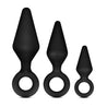 Three black butt plugs, each with a tapered tip and slim neck. Each features a reinforced ring at the base for safety. This anal trainer kit features a small, medium, and large plug. Additional images show alternate angles.