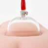 A clear oval cup designed to cup the vulva. Features an air release lever. Cylinder connects to a black trigger pump by red silicone hose.  Additional images show alternate angles.