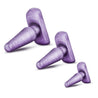 Three tapered purple swirl anal plugs in progressive sizes stand side by side. Other photos show alternate angles. 