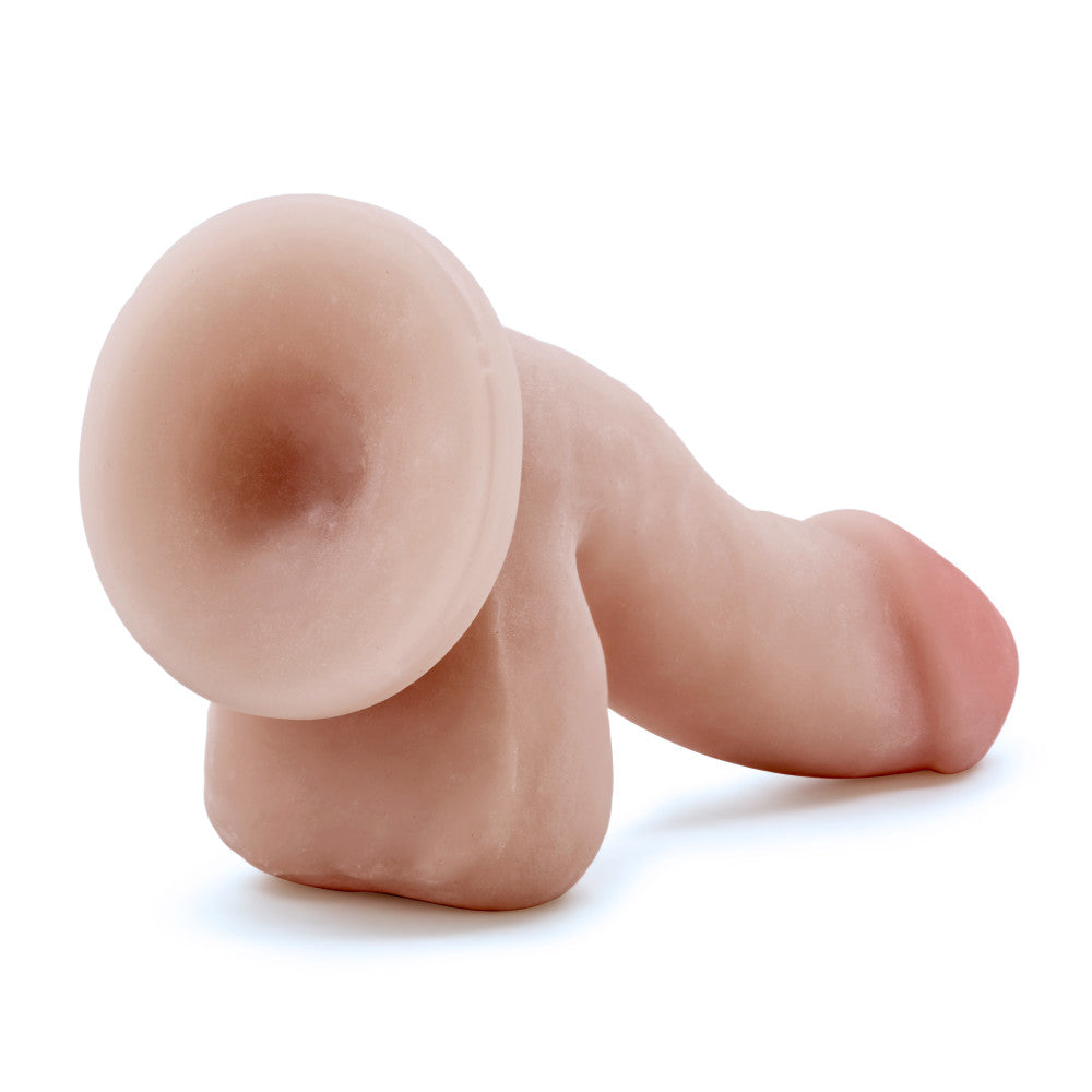 Vanilla skin tone realistic dildo. Featuring a realistic head. Head is slightly tinted in a pink color for a lifelike look. Veins along the shaft, which has an upward curve. Realistic balls. Suction cup base. Additional images show alternate angles.